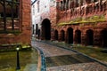 Wet paved road between old buildings