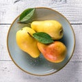 Wet pears with leaves on blue plate Royalty Free Stock Photo