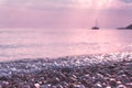 Wet pebble stones and sailing boat at morning seaside Royalty Free Stock Photo