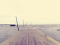 Wet pier in smooth water of sea bay. Mole anchored with steel poles into bottom Royalty Free Stock Photo