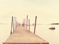 Wet pier in smooth water of sea bay. Mole anchored with steel poles into bottom Royalty Free Stock Photo