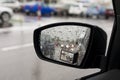 Wet by the rain the car mirror, blurry cars in mirror. Royalty Free Stock Photo