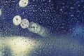 Wet, rainy window at night with water drops and blurry city lights Royalty Free Stock Photo