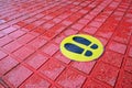 two shoe marks black on a yellow sticker marking of area and zone safety signs
