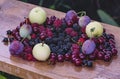 Summer gifts, wet and ripe blackberries, red cherries, raspberries, black currants, apples and plums lie on a wooden surface Royalty Free Stock Photo