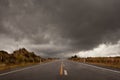 Wet road leading into a storm cloudy sky Royalty Free Stock Photo