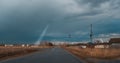 Wet road, storm clouds. In the background you can see a UFO. A ray of light from the sky. Unidentified flying objects that take on