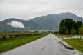 Wet roads of rural Idaho Swan Valley going into the Teton Mountain range on a rainy summer day Royalty Free Stock Photo