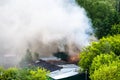 Wet roofs, burning garage and white smoke Royalty Free Stock Photo