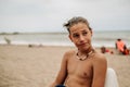 Wet boy sitting on the beach and thinking Royalty Free Stock Photo