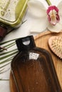 Wet shampoo bottles, hair brush, palm leaf and orchid flower on grey table, flat lay Royalty Free Stock Photo