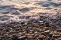 Wet shiny stones and small wave on the beach Royalty Free Stock Photo