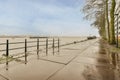 a wet sidewalk next to a body of water Royalty Free Stock Photo