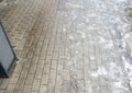 Wet and slippery cobblestone pavement in urban setting, covered with melting snow and ice, creates a challenging walking Royalty Free Stock Photo