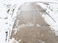 Wet slippery pavement with footprints. Dangerous ice. Muddy weather in winter. Car tire tracks. The work of municipal Royalty Free Stock Photo