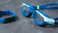 Wet swimming goggles and fitness bracelet on a stone background. Royalty Free Stock Photo