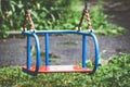 Wet swing on playground. Rainy summer weather_