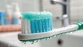 Wet toothpaste dripping from a toothbrush closeup in a softly lit bathroom environment Royalty Free Stock Photo