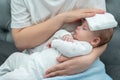 Wet towel comforts a feverish infant, Concept of mother& x27;s instinctive care response