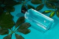 Wet transparent bottle of shower gel or shampoo is lying a beautiful blue background Royalty Free Stock Photo