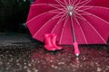 Wet umbrella and children`s rubber boots on wet asphalt Royalty Free Stock Photo