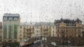 Wet window with drops on the background of the autumn city in cloudy weather. View from the window in the rain. Water drop on Royalty Free Stock Photo