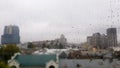 Wet window with drops on the background of the autumn city in cloudy weather. View from the window in the rain. Water drop on Royalty Free Stock Photo