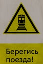 Wet yellow warning sign for trains passing nearby