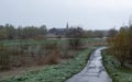 Wetland nature reserve with a wet cycling road and the village of Kalken in the background
