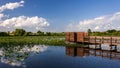 Wetlands landscape with a bird blind and cloudy sky reflected in a la6ke Royalty Free Stock Photo