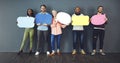 Weve all got our own opinions. Studio shot of a diverse group of people holding up speech bubbles against a gray Royalty Free Stock Photo