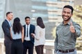 Weve got it from here. a handsome young businessman standing outside and showing a thumbs up while his colleagues Royalty Free Stock Photo