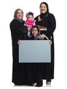 Weve got a lot to say. Studio portrait of the female members of a muslim family holding up a blank sign isolated on Royalty Free Stock Photo
