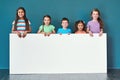 Weve got a message for you. Studio portrait of a diverse group of kids standing behind a large blank banner against a Royalty Free Stock Photo