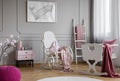 Whale poster on grey wall in child`s bedroom interior with rocking chair next to cradle. Real photo Royalty Free Stock Photo