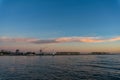 Wharf with hoisting crane and lighthouse at dusk