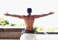 What a beautiful morning. A rear view shot of a muscular young man stretching while sitting on an exercise ball. Royalty Free Stock Photo