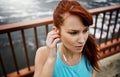 What better motivator than music. a sporty young woman listening to music while out for a run in the city.