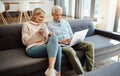 What better way to spend a retirement. a mature couple using a laptop on the sofa at home.