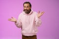 So what bite me. Portrait ignorant careless cool stylish mature bearded man earring pink hoodie shrugging hands sideways Royalty Free Stock Photo