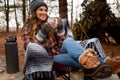 What a blissful and beautiful experience. a young woman drinking a warm beverage while camping in the wilderness during