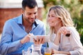 What can we do after breakfast. a young couple using a digital tablet while eating breakfast. Royalty Free Stock Photo