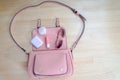 What comes from an open bag? Cosmetics, silver and accessories of women fall out of pink handbags.