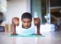 This is what commitment looks like. Shot of a young man doing push ups on an exercise mat. Royalty Free Stock Photo