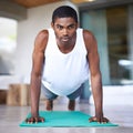 This is what commitment looks like. a young man doing push ups on an exercise mat. Royalty Free Stock Photo