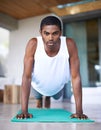 This is what commitment looks like. a young man doing push ups on an exercise mat. Royalty Free Stock Photo