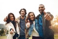 What a cool bunch friends I have. Portrait of a group of cheerful young friends huddled together while showing thumbs up Royalty Free Stock Photo