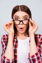 What?! Cute amazed brunette girl in glasses and checkered casual Royalty Free Stock Photo