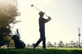 What a day for golfing. a focused young male golfer about to swing and play a shot with his golf club outside on a Royalty Free Stock Photo