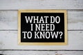 What Do I Need to Know? text with blackboard on wooden background Royalty Free Stock Photo